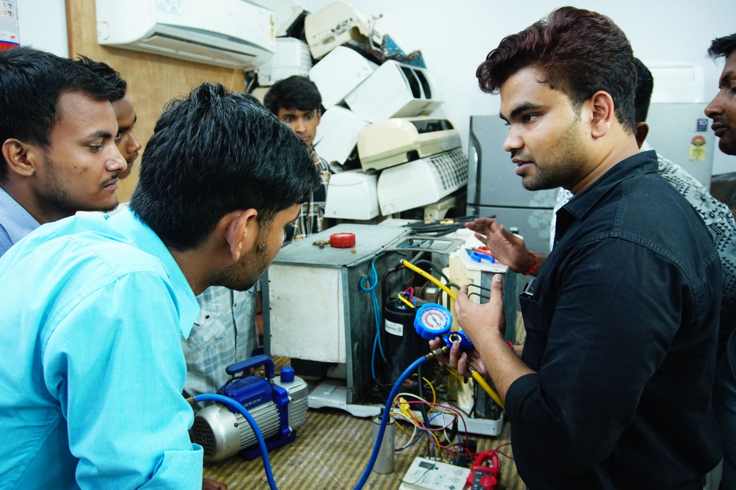 Young men learning appliance repair at a vocational training session in India